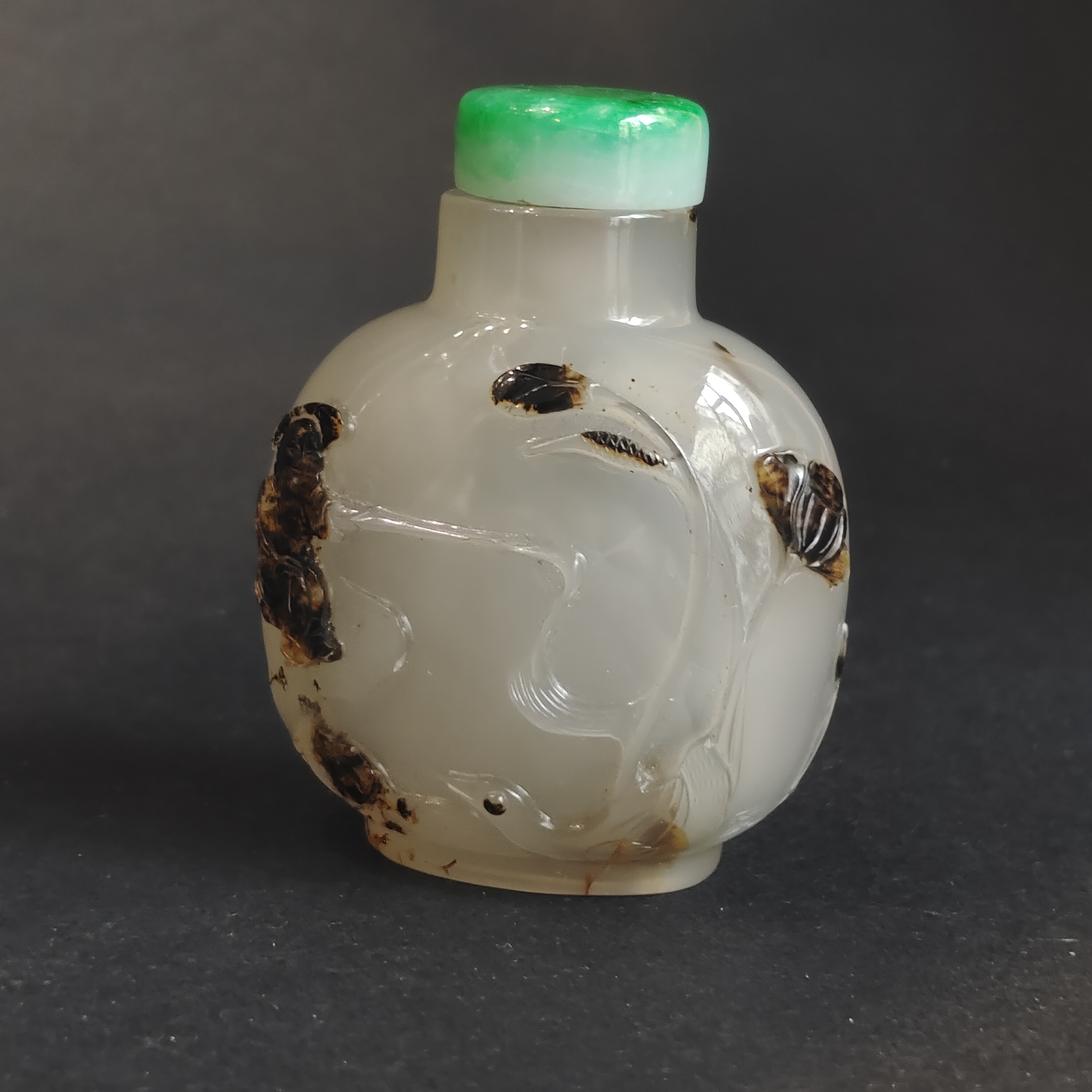 Snuff Bottles : Very well hollowed agate snuff bottle carved in a brown vein from a fisherman at the edge of the water with duck and frog near lotus and millet - on the reverse Zhang Qian on a tree trunk forming a boat -
China official school 1750/1850