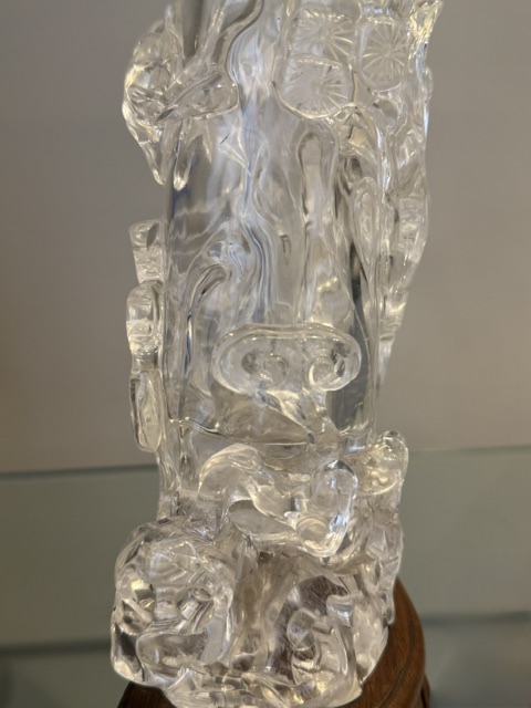 Works of Art : Rock crystal vase of bamboo double trunk form ,the sides carved in relief with pines and a bird perched on the branch facing a deer ,and a tree with grenades adorned with a phenix standing on a rock base facing a qilong at the top of the vase 
China 19th century    H 19cm
with wood stand
