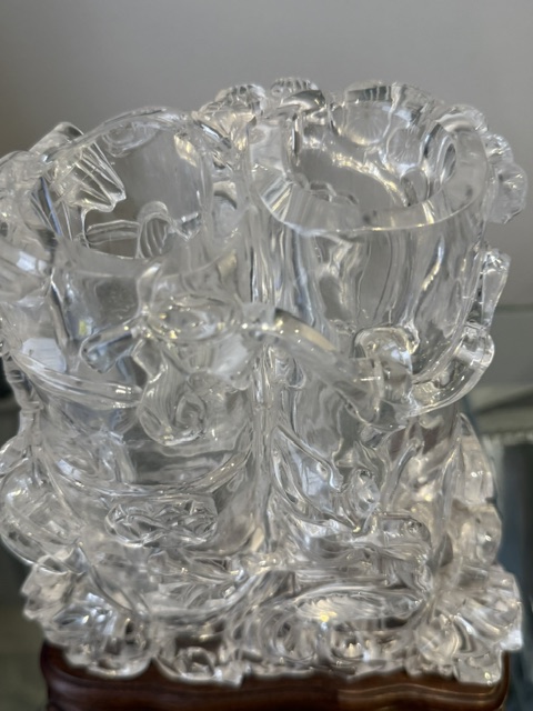 Works of Art : Rock crystal vase of bamboo double trunk form ,the sides carved in relief with pines and a bird perched on the branch facing a deer ,and a tree with grenades adorned with a phenix standing on a rock base facing a qilong at the top of the vase 
China 19th century    H 19cm
with wood stand

